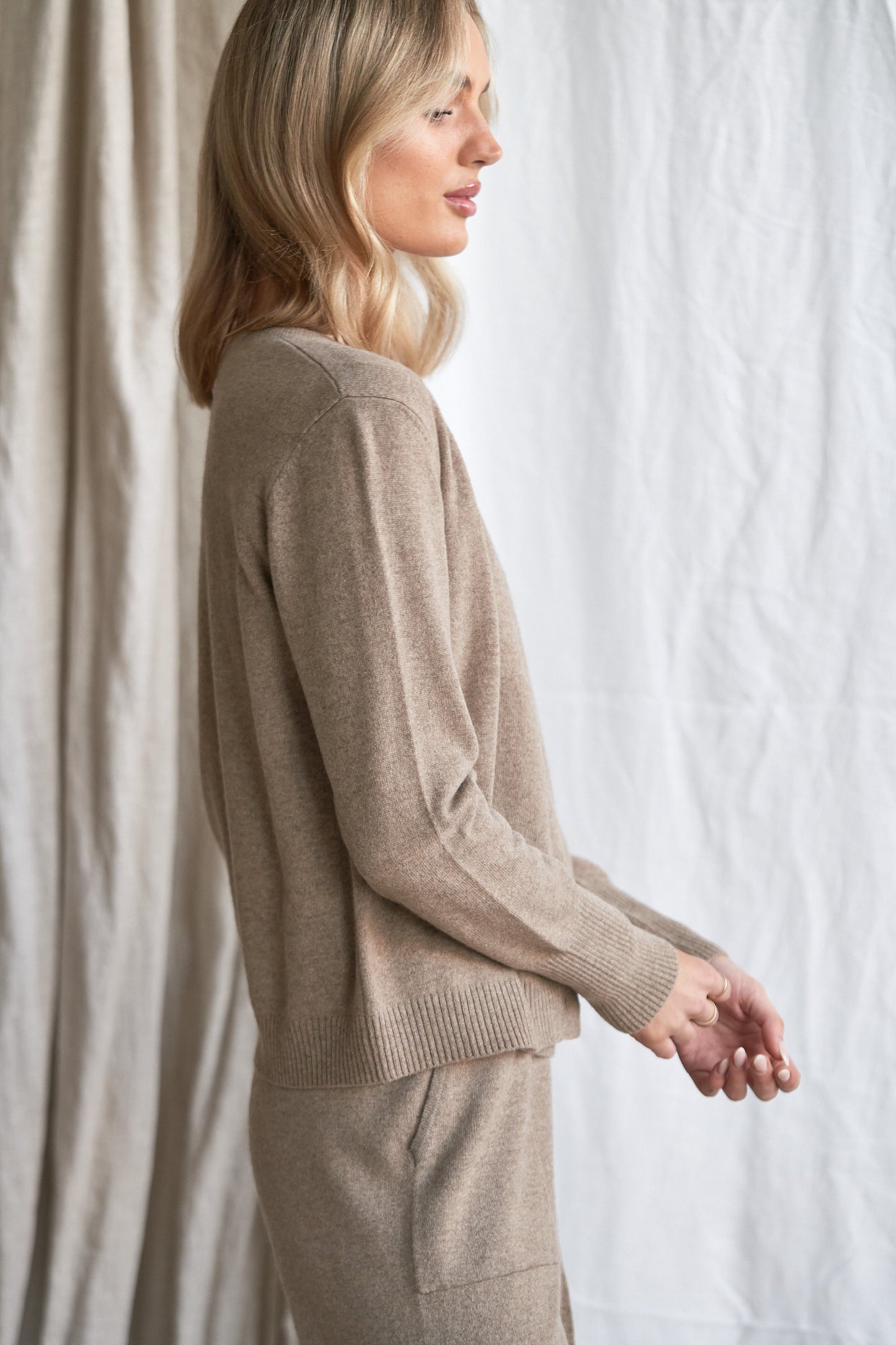 Mushroom Cashmere Cardigan – Women’s Knitwear with Mother-of-Pearl Buttons | 100% Pure Cashmere
Refined and versatile, our mushroom cashmere cardigan is a wardrobe essential for cool weather layering. Made from 100% ethically sourced pure cashmere, this women’s knit features a soft neutral taupe-grey hue and is finished with natural mother-of-pearl buttons for a delicate, elevated touch.
With a relaxed fit and luxurious softness, this cardigan is ideal for work, weekends, or travel. Lightweight yet warm,