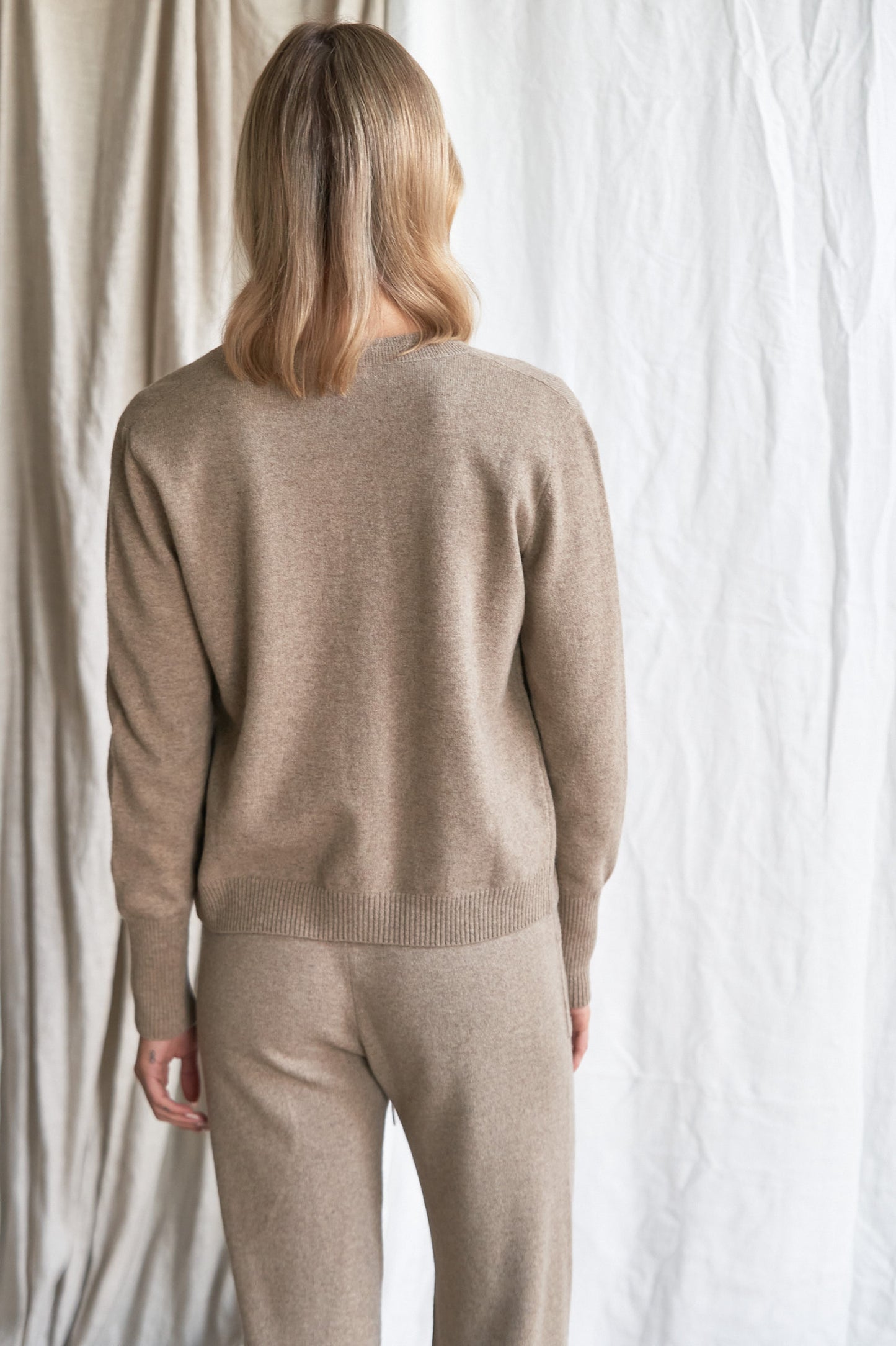 Mushroom Cashmere Cardigan – Women’s Knitwear with Mother-of-Pearl Buttons | 100% Pure Cashmere
Refined and versatile, our mushroom cashmere cardigan is a wardrobe essential for cool weather layering. Made from 100% ethically sourced pure cashmere, this women’s knit features a soft neutral taupe-grey hue and is finished with natural mother-of-pearl buttons for a delicate, elevated touch.
With a relaxed fit and luxurious softness, this cardigan is ideal for work, weekends, or travel. Lightweight yet warm,