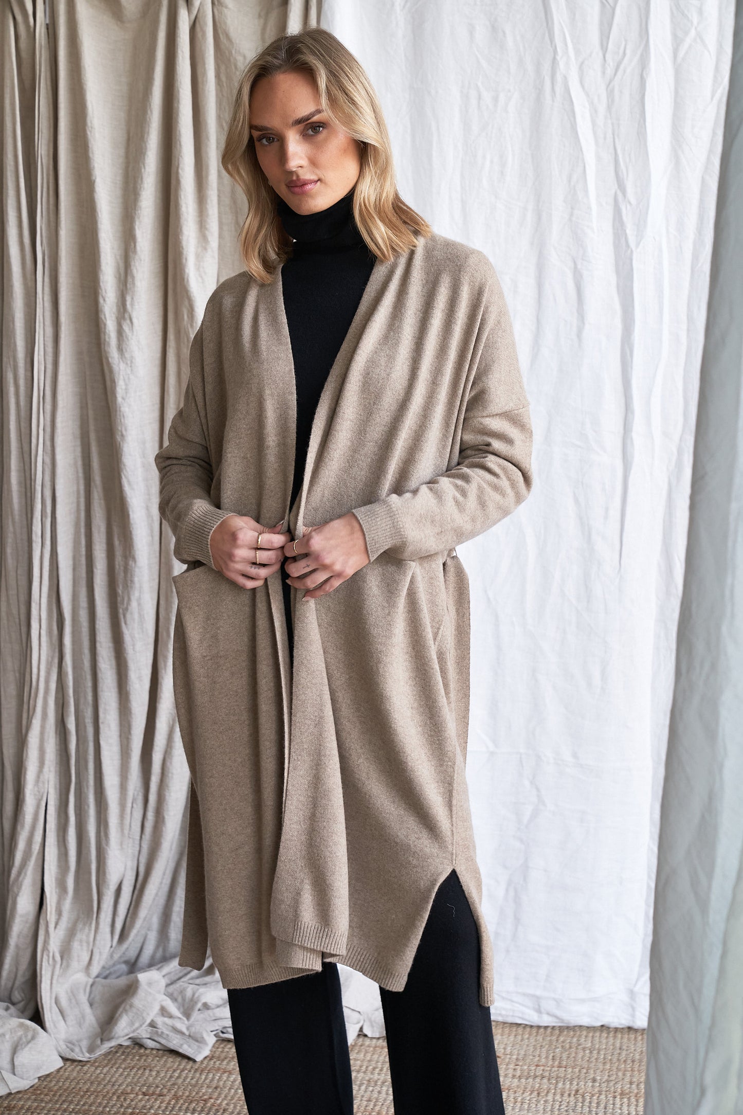 Long Mushroom Cashmere Cardigan with Belt & Pockets – Women’s Coatigan | 100% Pure Cashmere
Wrap yourself in luxury with our long cashmere cardigan in mushroom, designed with a soft belted waist and practical front pockets. Made from 100% pure, ethically sourced cashmere, this elegant coatigan-style knit offers a relaxed, robe-like silhouette perfect for layering during cooler months.
The neutral taupe-grey tone makes it endlessly versatile, while the detachable belt allows for multiple styling options. W