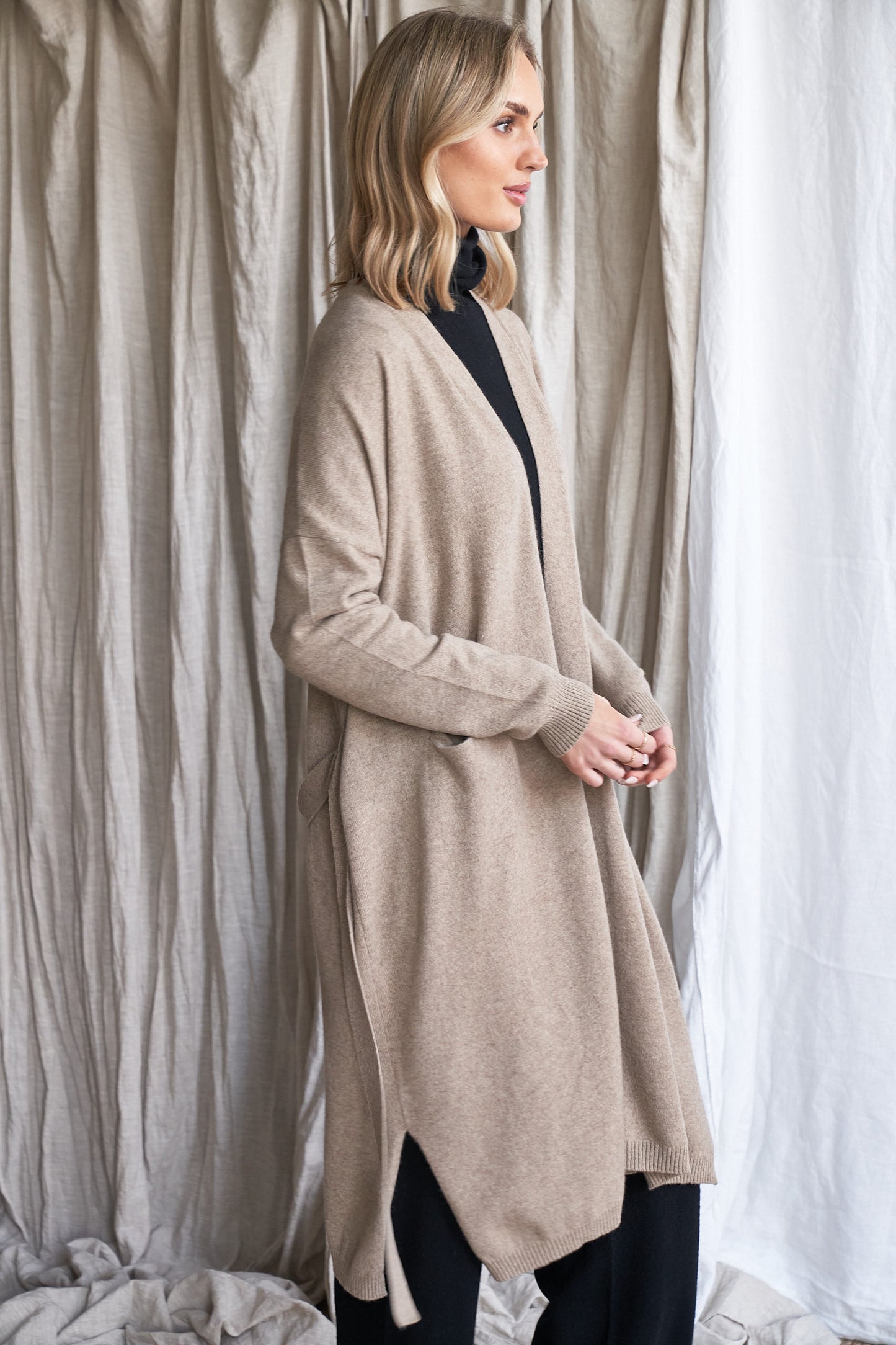 Long Mushroom Cashmere Cardigan with Belt & Pockets – Women’s Coatigan | 100% Pure Cashmere
Wrap yourself in luxury with our long cashmere cardigan in mushroom, designed with a soft belted waist and practical front pockets. Made from 100% pure, ethically sourced cashmere, this elegant coatigan-style knit offers a relaxed, robe-like silhouette perfect for layering during cooler months.
The neutral taupe-grey tone makes it endlessly versatile, while the detachable belt allows for multiple styling options. W