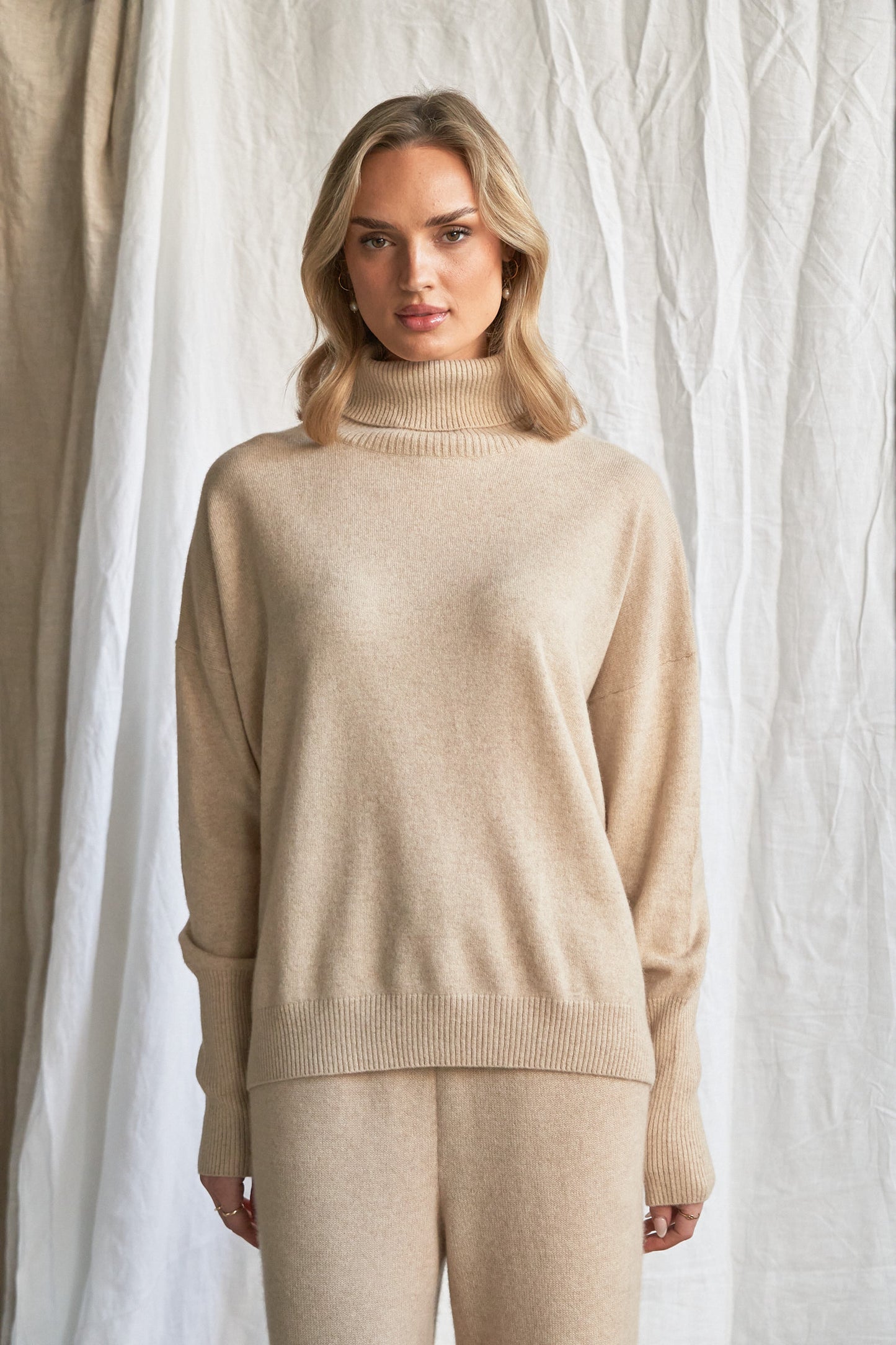 Indulge in the soft luxury of our oversized oatmeal cashmere sweater, designed with a high neckline and relaxed fit for all-day comfort. Made from 100% pure, ethically sourced cashmere, this roomy women’s knit features wide sleeves, drop shoulders, and a soft neutral hue that complements every wardrobe.
Perfect for layering or lounging, this high neck oversized sweater is a modern essential for effortless cold-weather dressing. Soft, breathable, and naturally insulating — it’s winter comfort with elevated