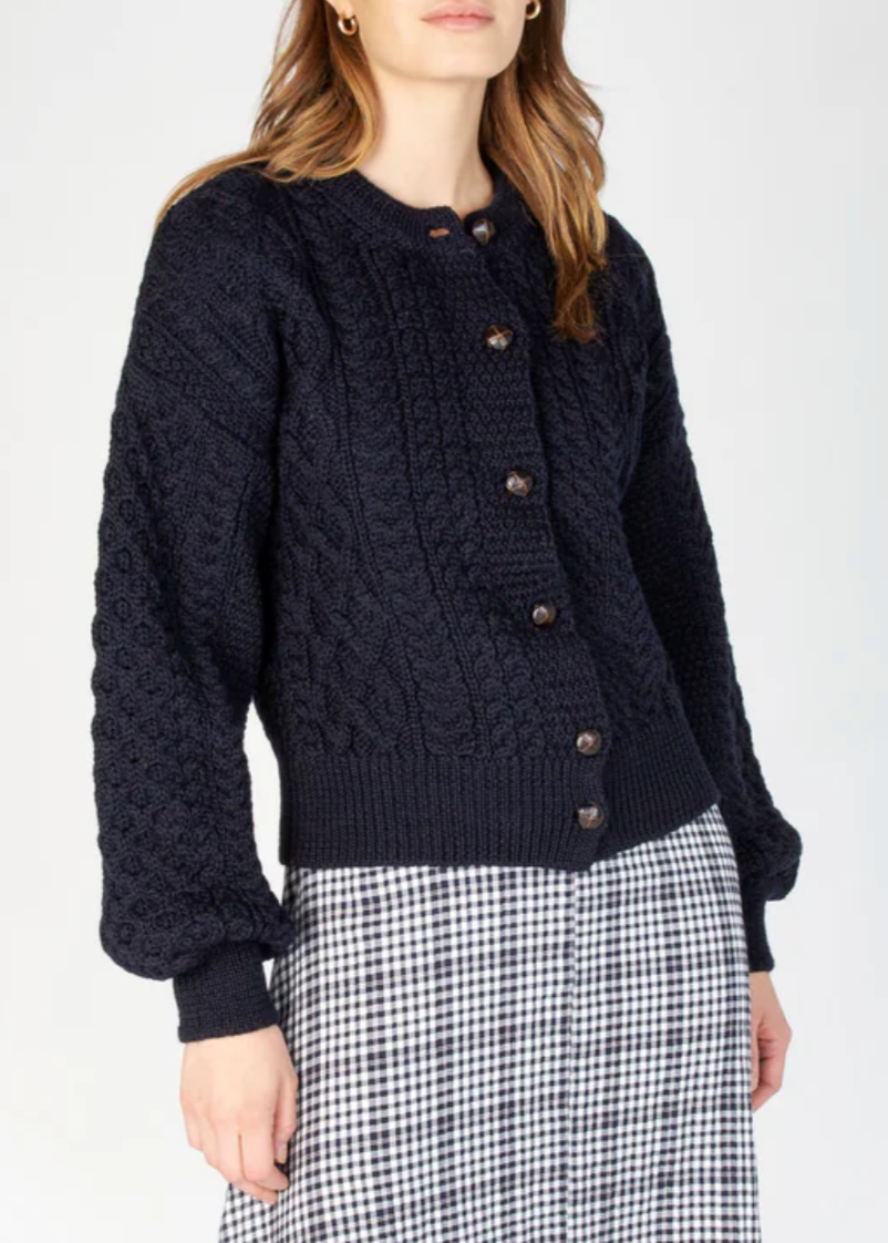 This cardigan showcases an artful blend of traditional knit techniques, featuring classic Aran-inspired cables, honeycomb textures, and basketweave patterns throughout. Each stitch is thoughtfully placed, creating a visually rich and tactile fabric that feels as cozy as it looks. The chunky knit design offers a warm, breathable layer perfect for cooler seasons, while the voluminous sleeves and ribbed trims add a modern finish to this timeless piece. Whether you're dressing it up or down, this knit is a stan