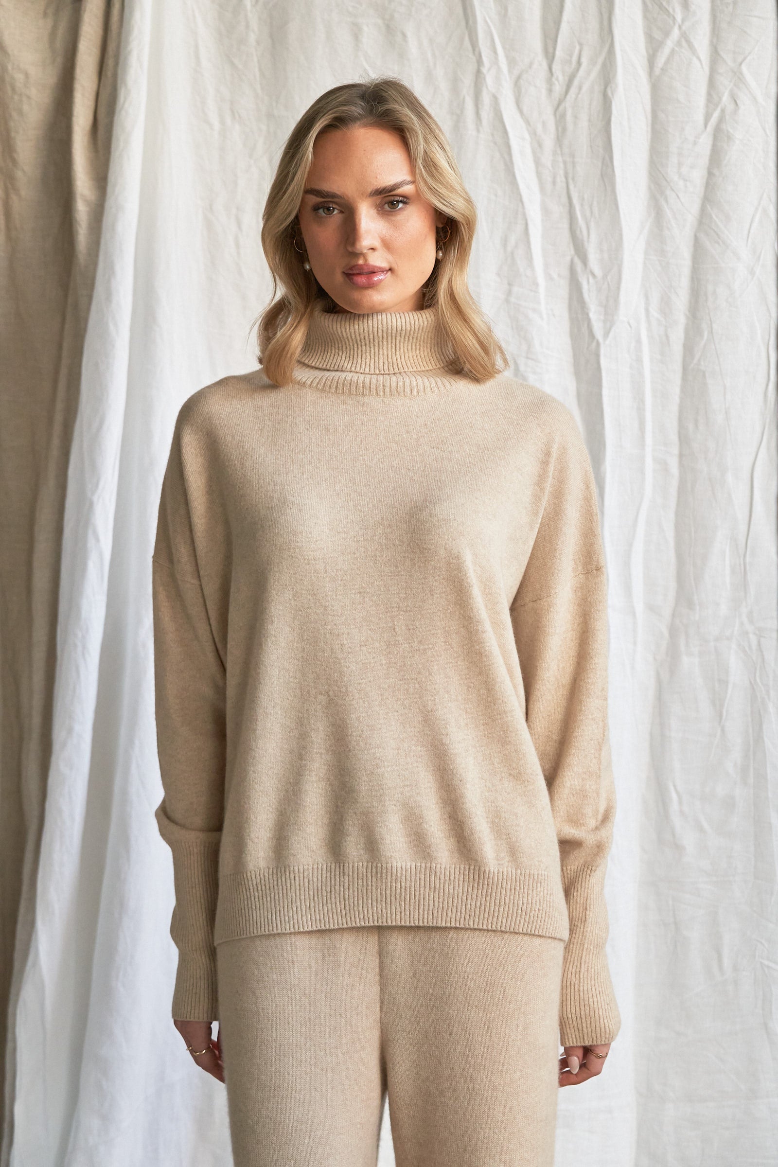 Indulge in the soft luxury of our oversized oatmeal cashmere sweater, designed with a high neckline and relaxed fit for all-day comfort. Made from 100% pure, ethically sourced cashmere, this roomy women’s knit features wide sleeves, drop shoulders, and a soft neutral hue that complements every wardrobe.

Perfect for layering or lounging, this high neck oversized sweater is a modern essential for effortless cold-weather dressing. Soft, breathable, and naturally insulating — it’s winter comfort with elevated 