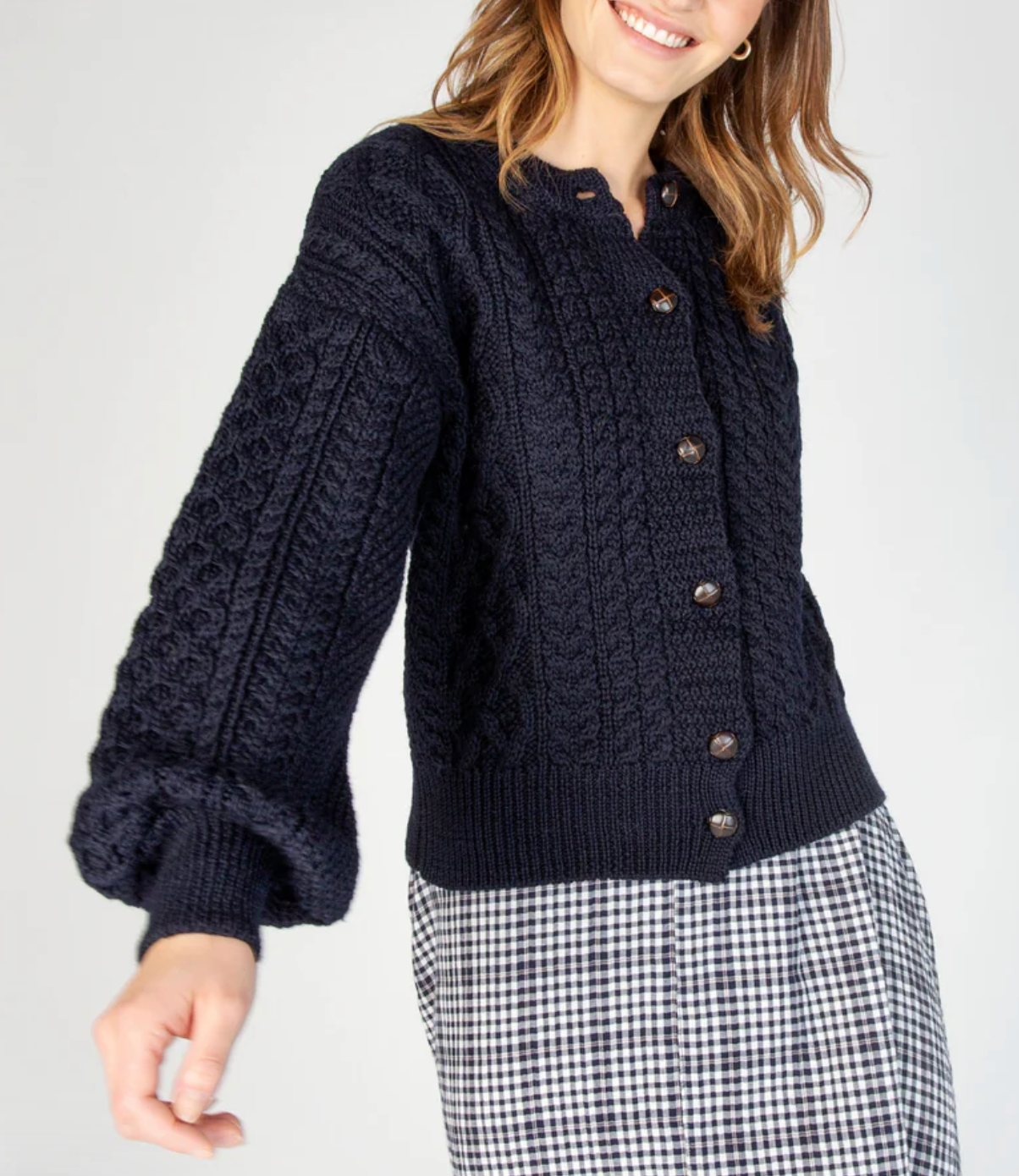 This cardigan showcases an artful blend of traditional knit techniques, featuring classic Aran-inspired cables, honeycomb textures, and basketweave patterns throughout. Each stitch is thoughtfully placed, creating a visually rich and tactile fabric that feels as cozy as it looks. The chunky knit design offers a warm, breathable layer perfect for cooler seasons, while the voluminous sleeves and ribbed trims add a modern finish to this timeless piece. Whether you're dressing it up or down, this knit is a stan